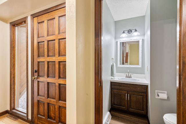 2036 Wendemere Ct, Jefferson City, MO 65109 - bathroom featuring toilet, vanity, wood finished floors, and baseboards