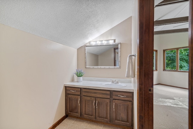2036 Wendemere Ct, Jefferson City, MO 65109 - bathroom with vaulted ceiling, a textured ceiling, vanity, baseboards, and tile patterned flooring
