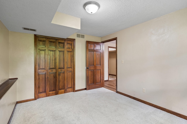 2036 Wendemere Ct, Jefferson City, MO 65109 - unfurnished bedroom with a textured ceiling, a closet, baseboards, and carpet flooring