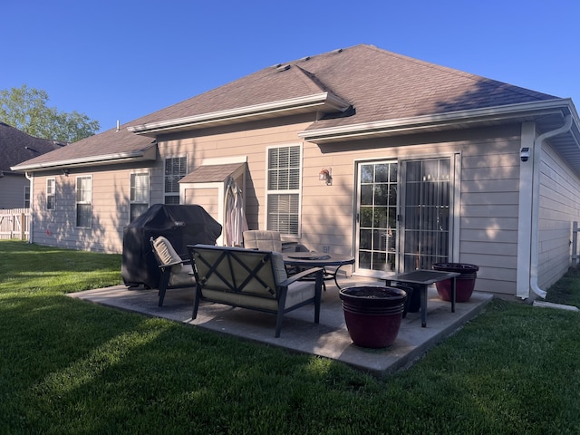 back of house with a patio, a yard, and roof with shingles