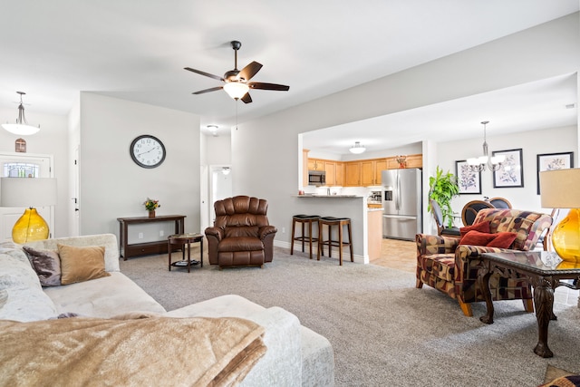 living area with light carpet, a chandelier, a ceiling fan, and baseboards