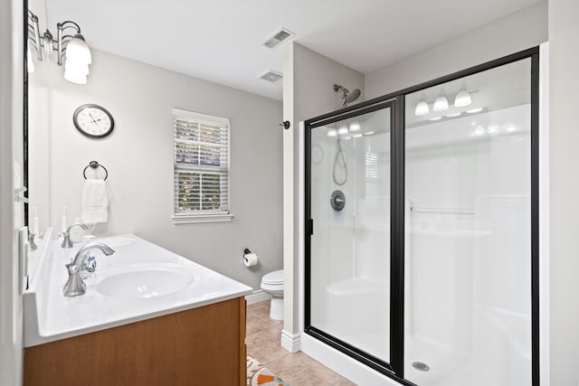 bathroom featuring a stall shower, tile patterned flooring, toilet, double vanity, and baseboards