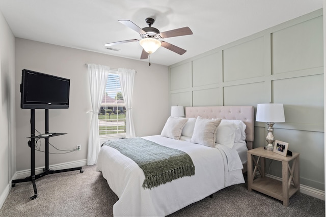 carpeted bedroom featuring baseboards, a ceiling fan, and a decorative wall