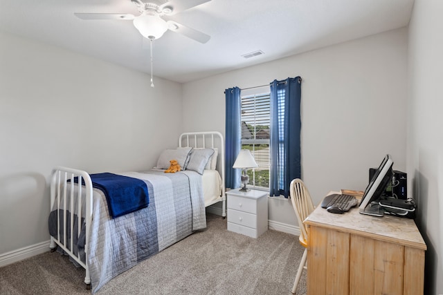 bedroom with light carpet, an office area, ceiling fan, and baseboards