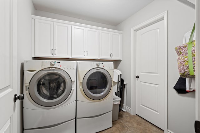 laundry area with washer and dryer, cabinet space, and light tile patterned floors