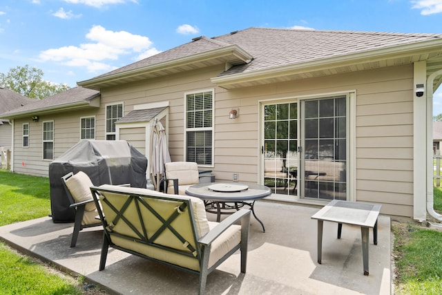 back of house featuring a patio area and roof with shingles