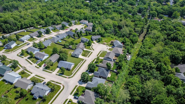 aerial view of property and surrounding area with nearby suburban area and a forest
