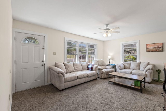 living area featuring baseboards, ceiling fan, and carpet floors