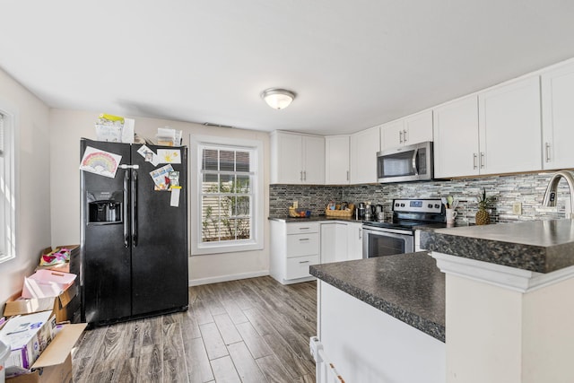 kitchen with backsplash, dark countertops, appliances with stainless steel finishes, and wood finished floors