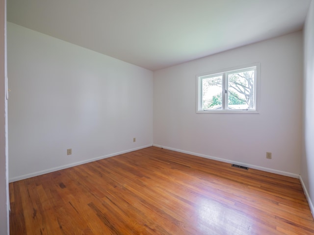 spare room with light wood-style floors and baseboards