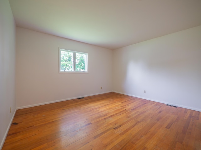 spare room with light wood finished floors and baseboards