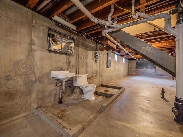 basement featuring electric panel and a sink