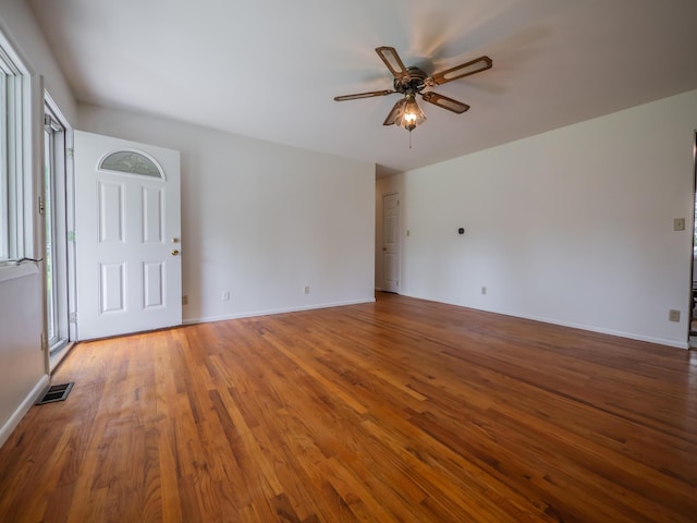 unfurnished room featuring a ceiling fan, wood finished floors, and baseboards