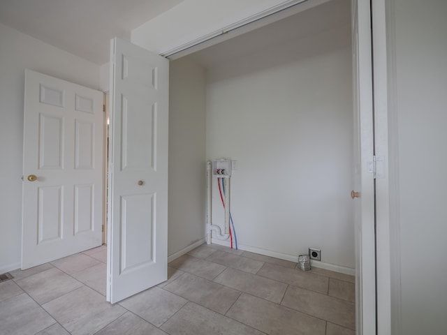 laundry area with light tile patterned floors, hookup for a washing machine, hookup for an electric dryer, and baseboards