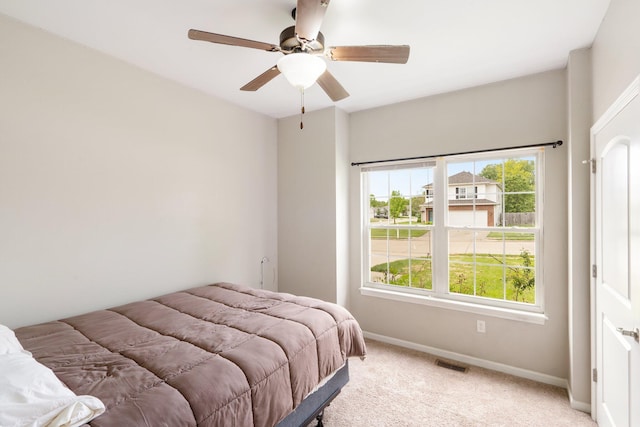 bedroom featuring light carpet, baseboards, and ceiling fan