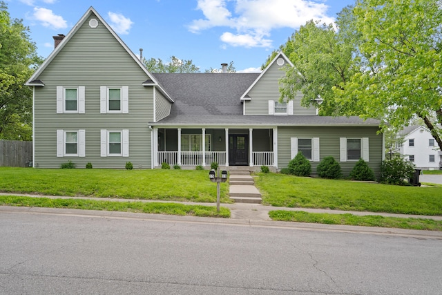 view of front facade with a porch, a chimney, a front lawn, and a shingled roof