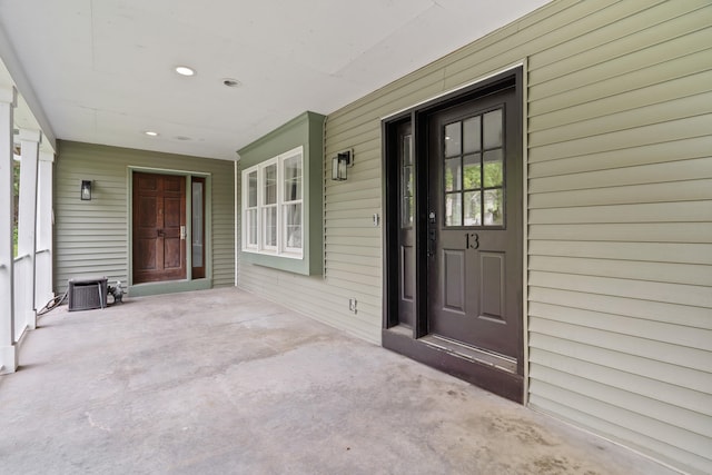 doorway to property with covered porch and central AC unit