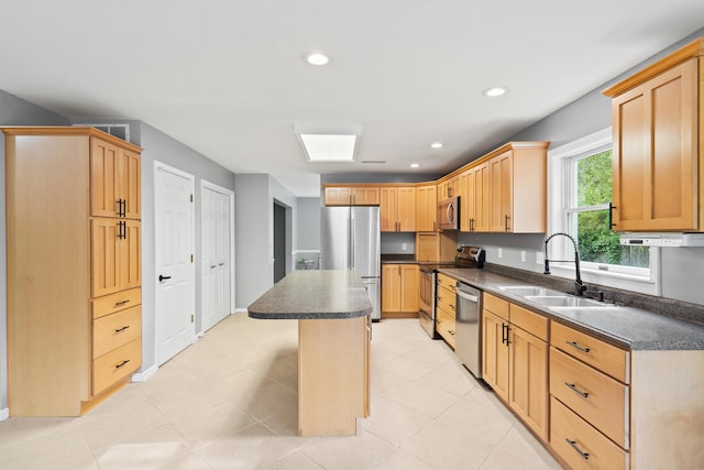 kitchen with appliances with stainless steel finishes, a sink, dark countertops, recessed lighting, and light brown cabinetry