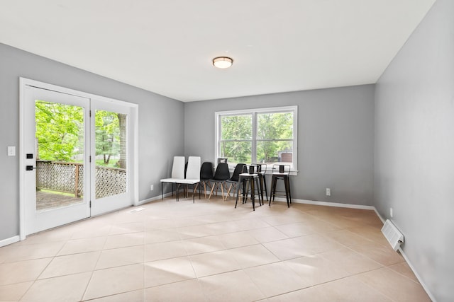 sitting room featuring healthy amount of natural light, tile patterned flooring, and baseboards