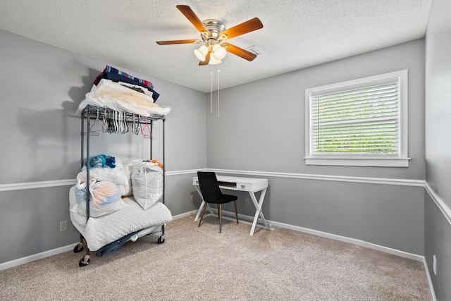 carpeted office space with ceiling fan, a textured ceiling, and baseboards