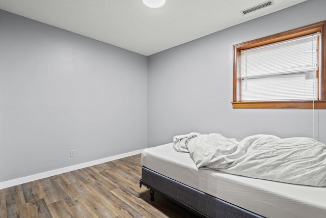 bedroom featuring wood finished floors and baseboards