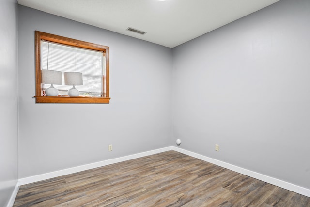 empty room featuring baseboards and wood finished floors