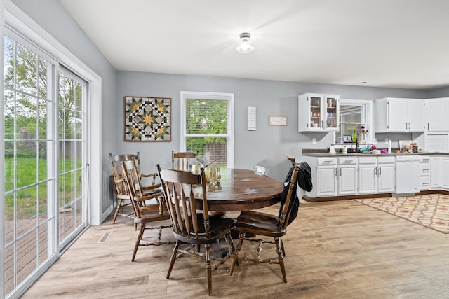 dining space with light wood-style flooring and healthy amount of natural light