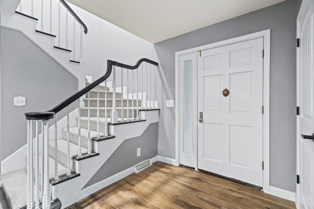 entrance foyer featuring stairway, baseboards, and wood finished floors