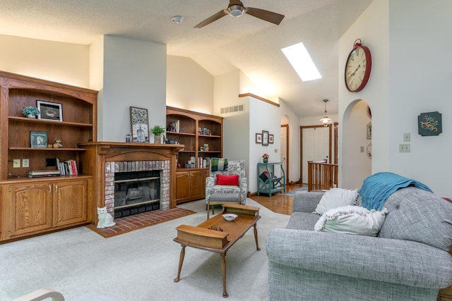 2105 Oak Point Ct, Columbia, MO 65203 - living room featuring arched walkways, ceiling fan, a fireplace, high vaulted ceiling, and a skylight