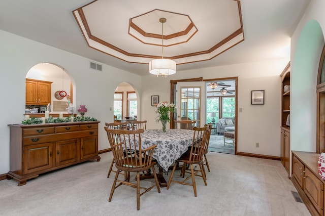 2105 Oak Point Ct, Columbia, MO 65203 - dining room with a tray ceiling, light carpet, arched walkways, baseboards, and a ceiling fan