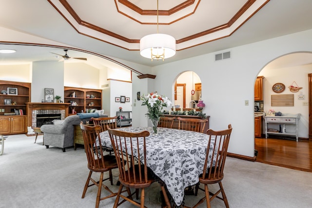 2105 Oak Point Ct, Columbia, MO 65203 - dining space with a tray ceiling, crown molding, light carpet, arched walkways, and ceiling fan