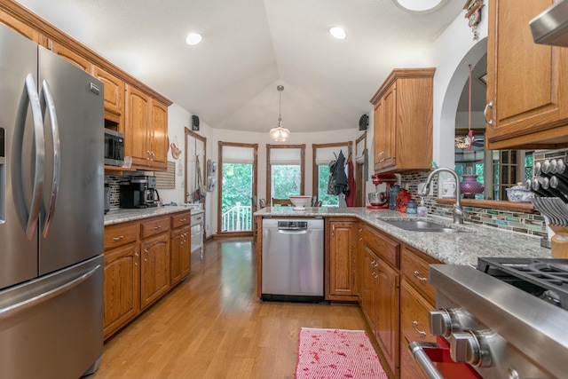 2105 Oak Point Ct, Columbia, MO 65203 - kitchen with appliances with stainless steel finishes, a sink, backsplash, brown cabinetry, and light wood finished floors