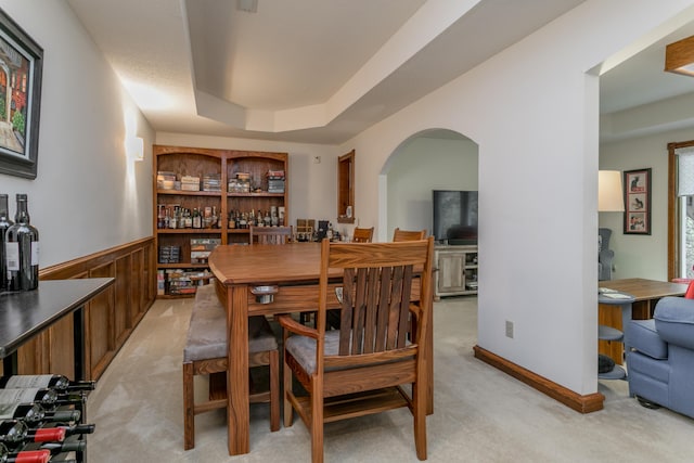 2105 Oak Point Ct, Columbia, MO 65203 - dining area with light carpet, arched walkways, a wainscoted wall, and a tray ceiling