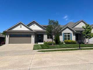 single story home featuring concrete driveway, a garage, and a front yard