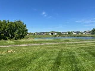 view of community featuring a water view and a yard