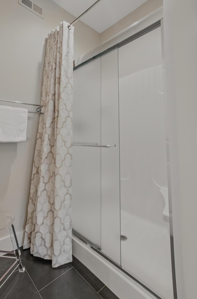 bathroom featuring a shower stall and tile patterned flooring