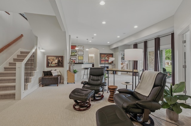 living room featuring carpet floors, arched walkways, recessed lighting, and stairway