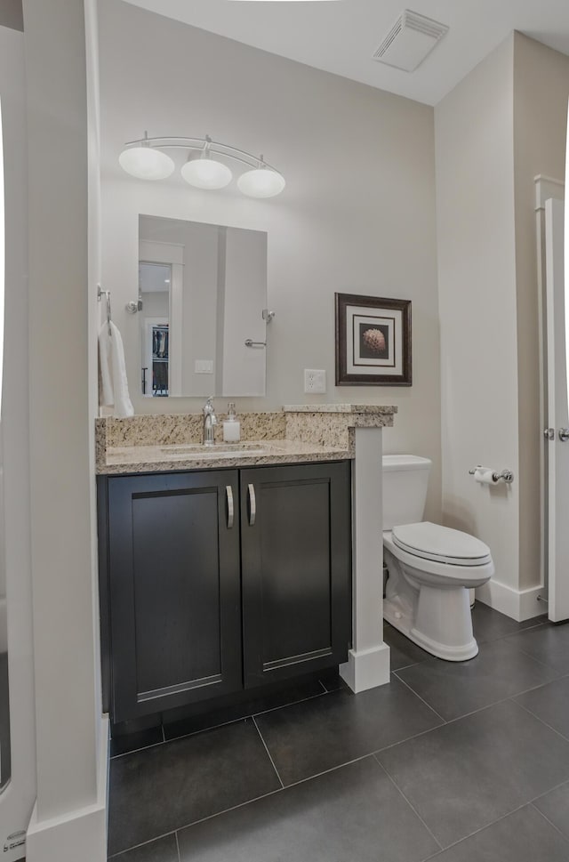 bathroom featuring tile patterned flooring, toilet, vanity, and baseboards