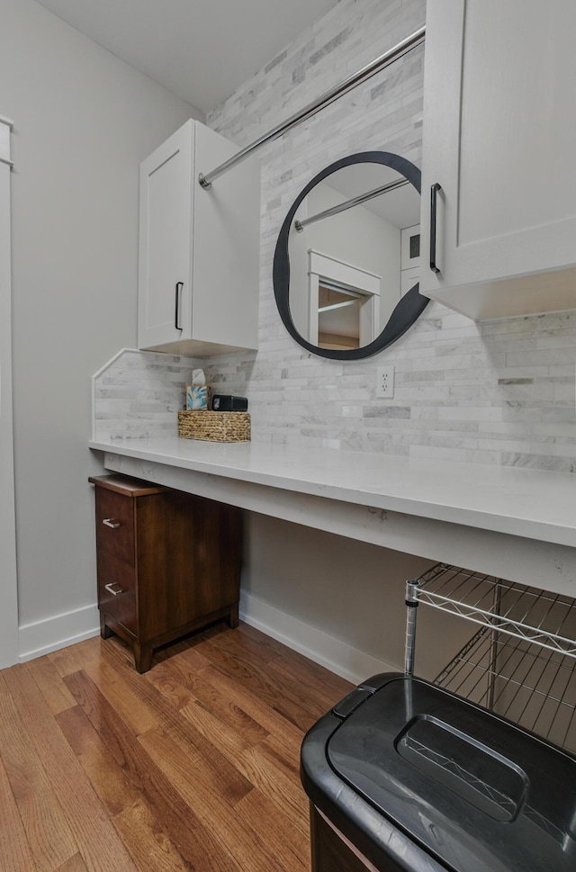 bathroom featuring decorative backsplash, wood finished floors, and baseboards