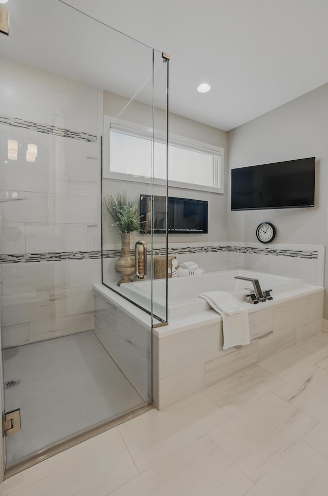 bathroom with a bath, a stall shower, and recessed lighting