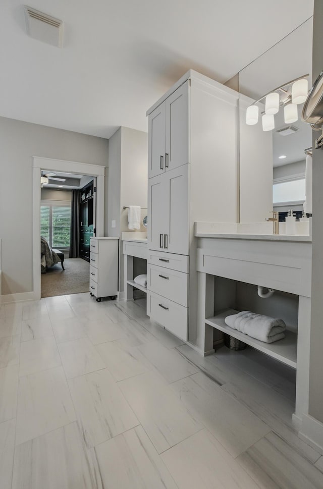bathroom with vanity, baseboards, and connected bathroom