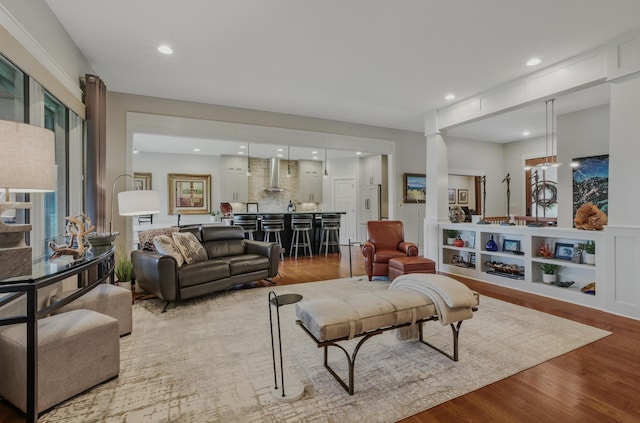 living room featuring wood finished floors, bar area, and recessed lighting