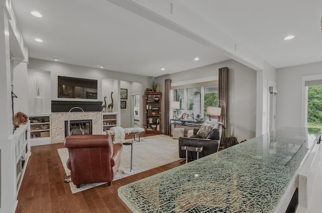 living room with dark wood finished floors, a glass covered fireplace, and recessed lighting