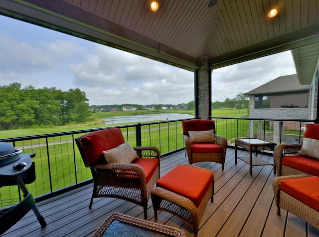 wooden terrace featuring a water view, a grill, and a lawn