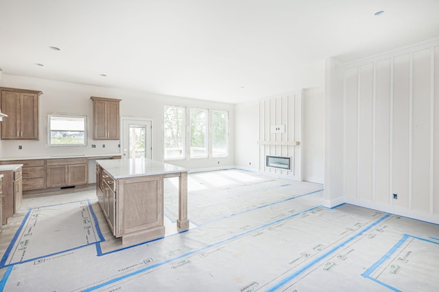 4725 Stayton Ferry Cir, Columbia, MO 65201 - kitchen with plenty of natural light, a fireplace, a kitchen island, and brown cabinets