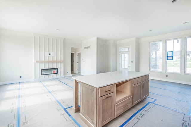 4725 Stayton Ferry Cir, Columbia, MO 65201 - kitchen with baseboards, open floor plan, a large fireplace, a center island, and light countertops