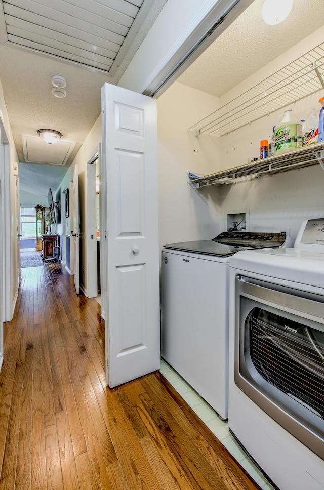 laundry area featuring independent washer and dryer and light wood-style floors