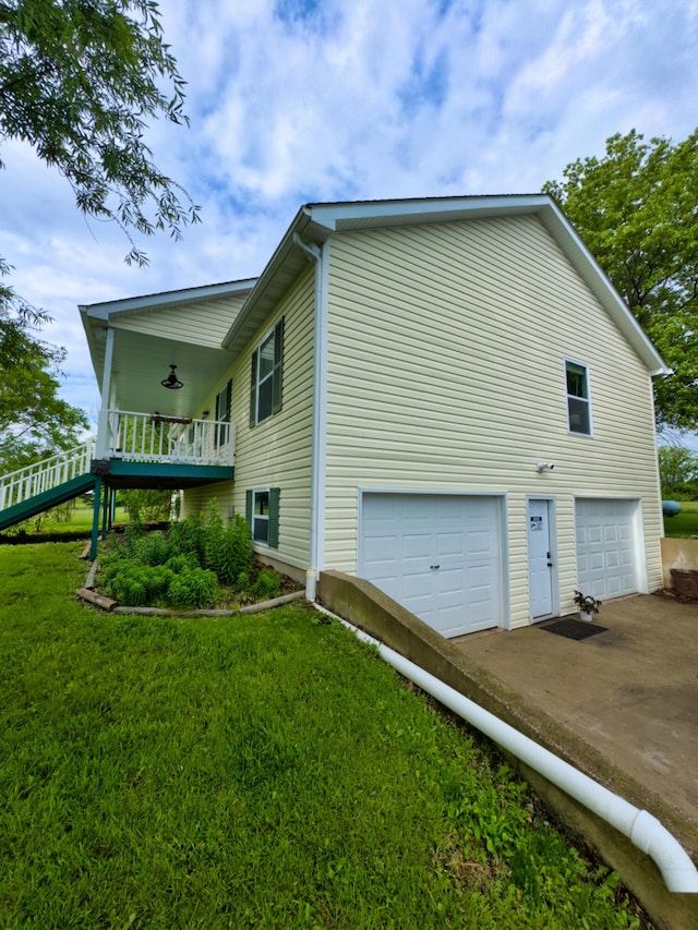 view of property exterior with an attached garage, driveway, and a lawn