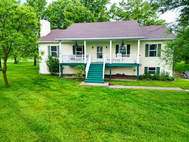 view of front facade with a porch, a chimney, stairs, and a front yard