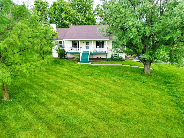 view of front of home with a front lawn, a chimney, and a porch